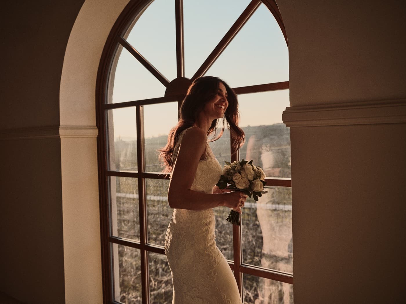 La sposa controluce alla grande finestra ad arco