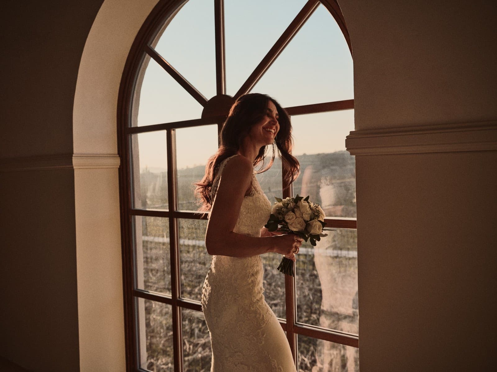 La sposa controluce alla grande finestra ad arco